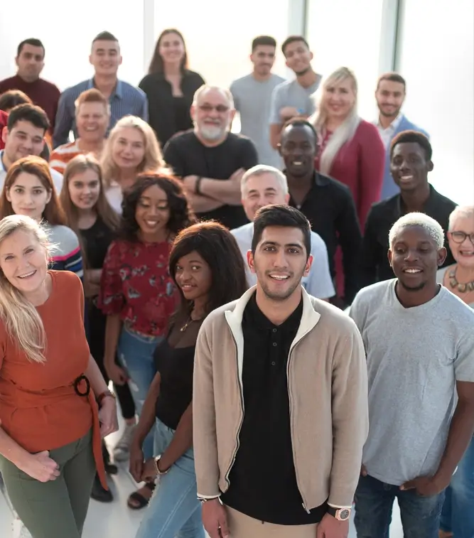 Diverse group of smiling people gathered indoors.