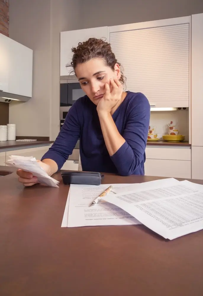 Woman reviewing documents, appearing concerned or thoughtful.